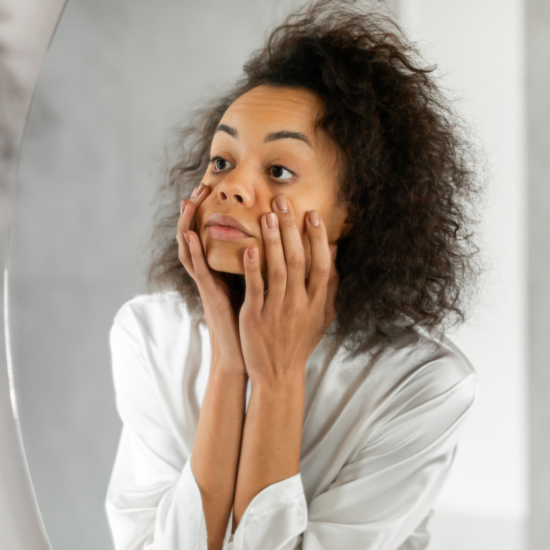 woman looking at her skin